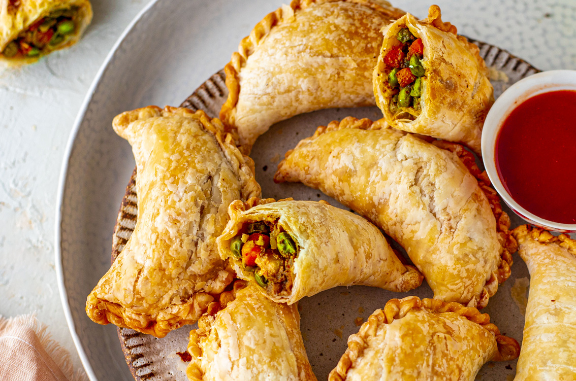 Freshly baked curry puffs with a golden, flaky crust, filled with savory spiced potatoes and chicken